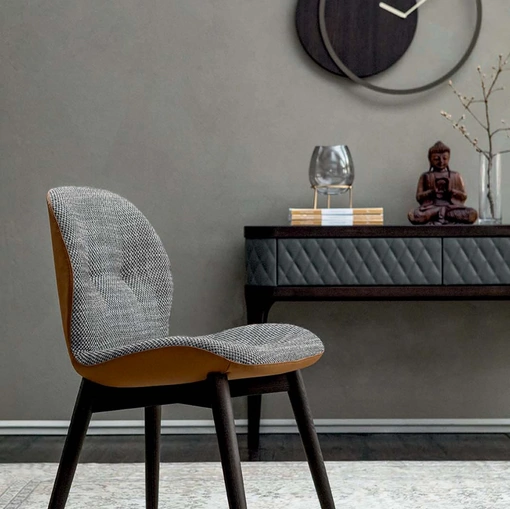 Sedia Sorrento Ésprit con seduta rivestita in tessuto e schienale in ecopelle con gambe in legno di Tonin Casa